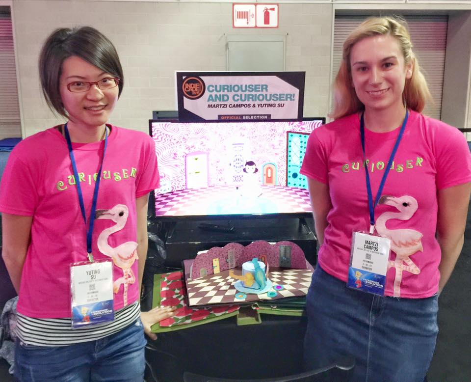 Martzi Campos, right, and Yuting Su stand with Curiouser and Curiouser! during E3 in Los Angeles. | Image courtesy of Martzi Campos